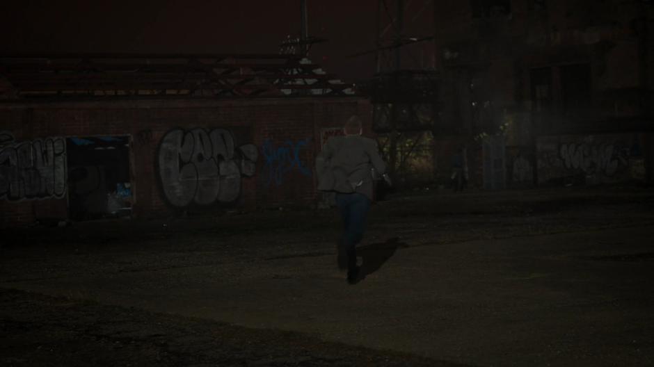 Connors runs after Tyrone towards the abandoned building.