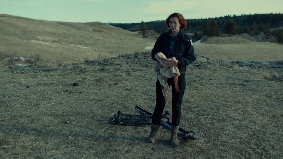 Nicole picks up Waverly's bloody scarf from the ground beside the crash.