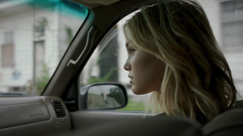 Tandy sits in the passenger seat of Liam's truck while they drive across town.