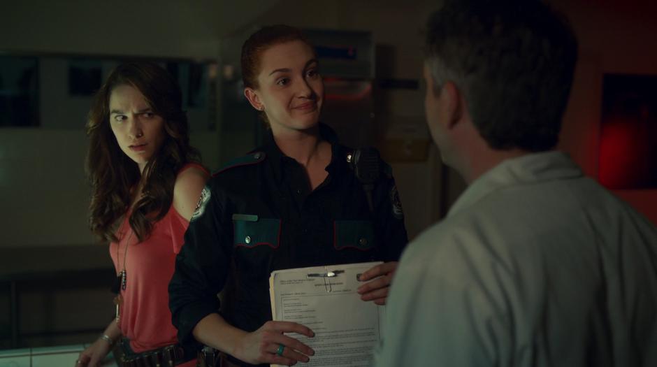 Nicole smiles in greeting at Dr. Reggie while Wynonna looks at him in suspicion.