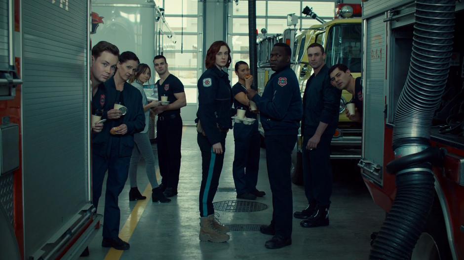 Nicole, Waverly, and all of the fire fighters look over at Wynonna as she gets out of the fire truck.