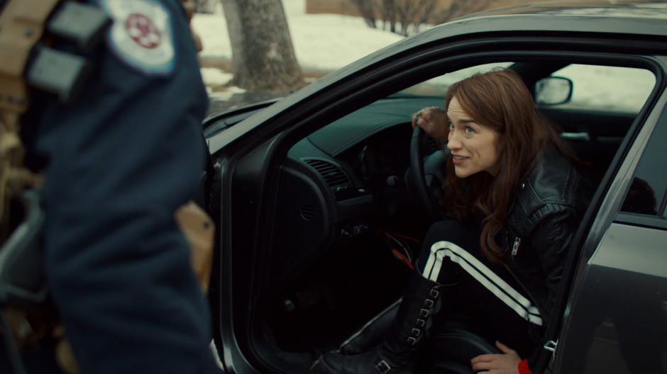 Wynonna looks up at Nicole from the driver's seat of Bunny's car after hotwiring it.
