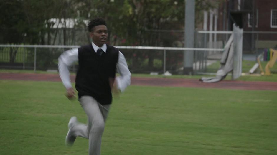 Tyrone runs across the field on his way to the gym.