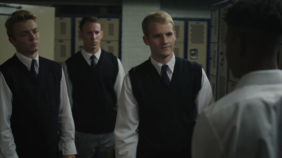 Three of Tyrone's teammates confront him in the locker room.