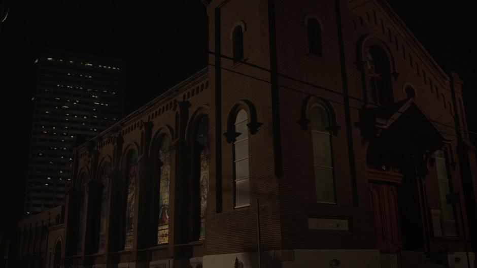 Tyrone's view of the church while he is walking down the street with Evita at night.