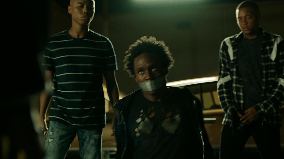 Will is pushed to the ground by two of the gang members with duct tape across his mouth.