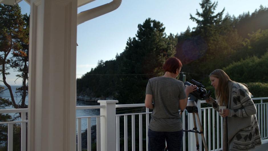 Alex walks over to Kara who is looking through her telescope on the porch.