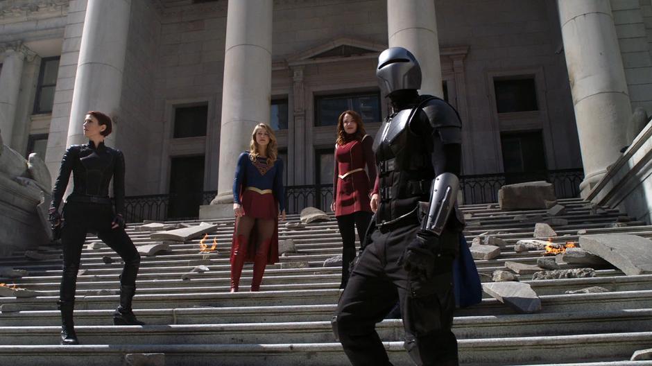 Alex, Kara, Alura, and James stand on the steps looking out over the crowd they saved.