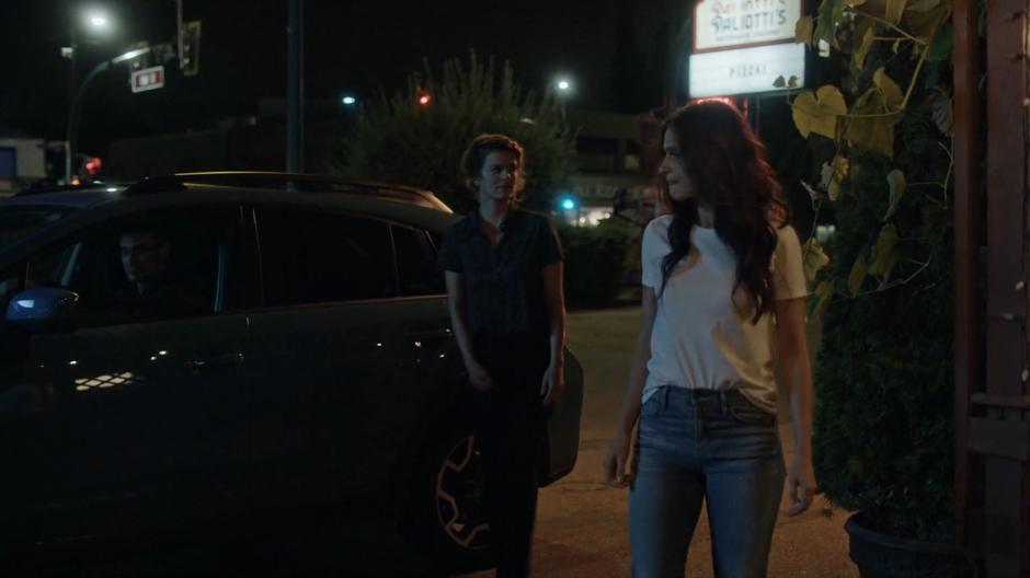 Izzy looks around suspiciously while Nina escorts her over to the pizza place.