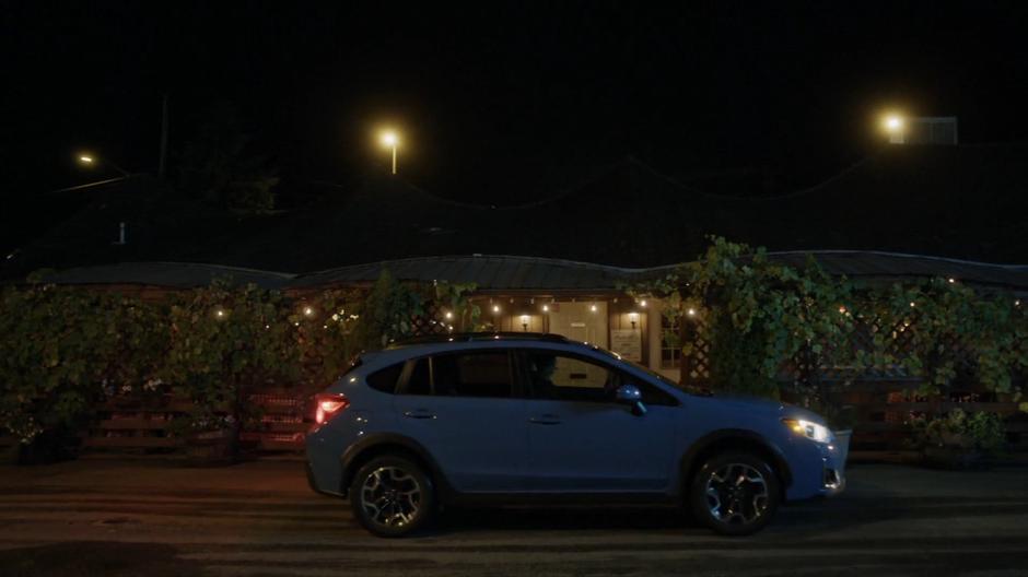 The car carrying Izzy and Nina pulls up in front of the pizza restaurant.