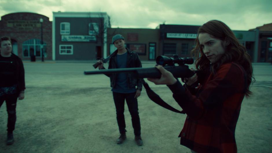 Wynonna points a rifle she looted at Rolf while the other Revenants surround her.