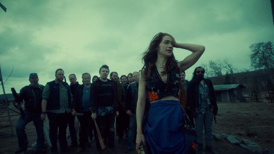 Wynonna puts her hand on her head while standing in front of the crowd of Revenants.