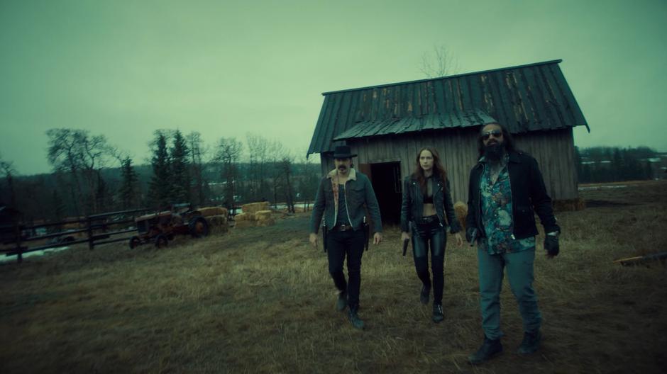 Doc and Wynonna walk over next to Jarvis and look up at the ridge where Bulshar's beekeepers are approaching.