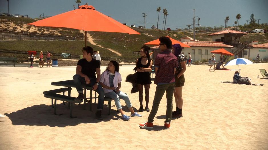 Chase, Molly, Nico, Alex, and Gert look over as Karolina walks over to them.