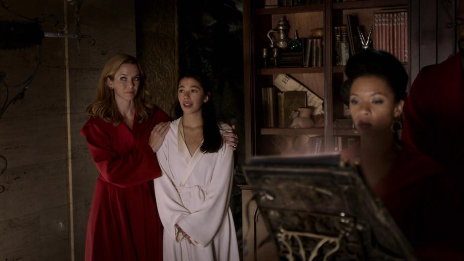 Leslie leads a nervous Destiny into the ritual room while Catherine prepares the book.