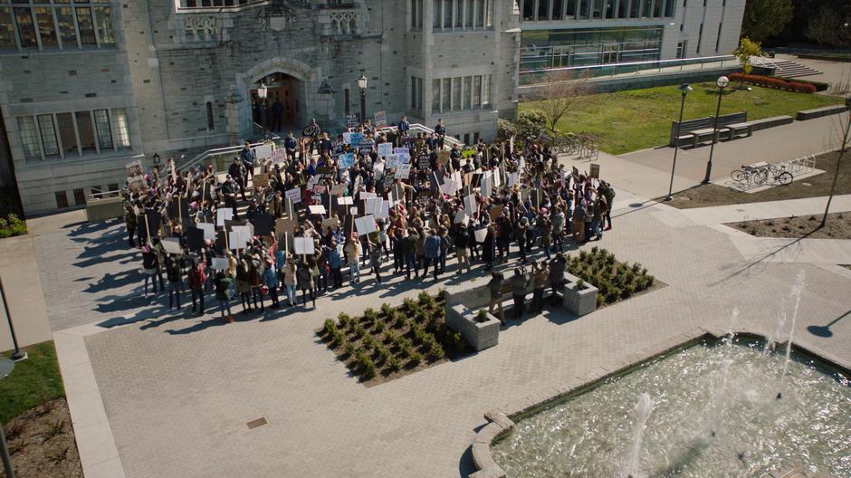 Mel and a number of other students protest Professor Thaine's reinstatement in front of the
