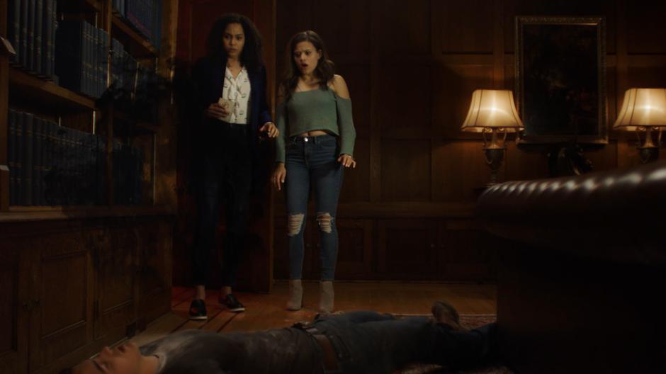 Macy and Maggie look down at Brian after cleansing him of the demon.