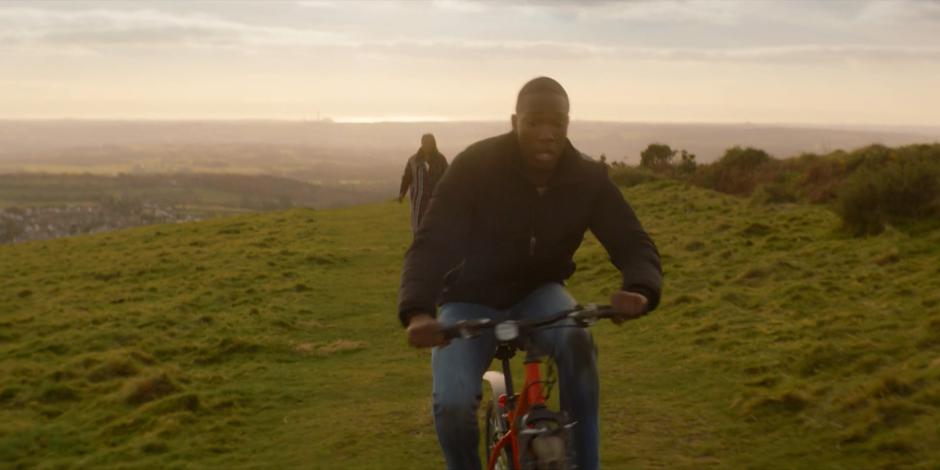 Grace watches from behind as Ryan begins to lose control of his bike.