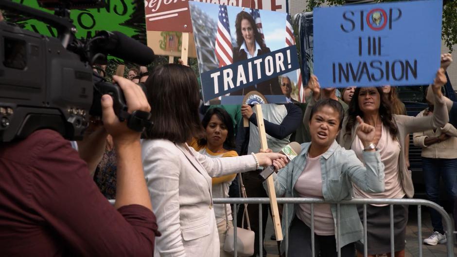 An anti-alien protestor yells while being interviewed by the news.