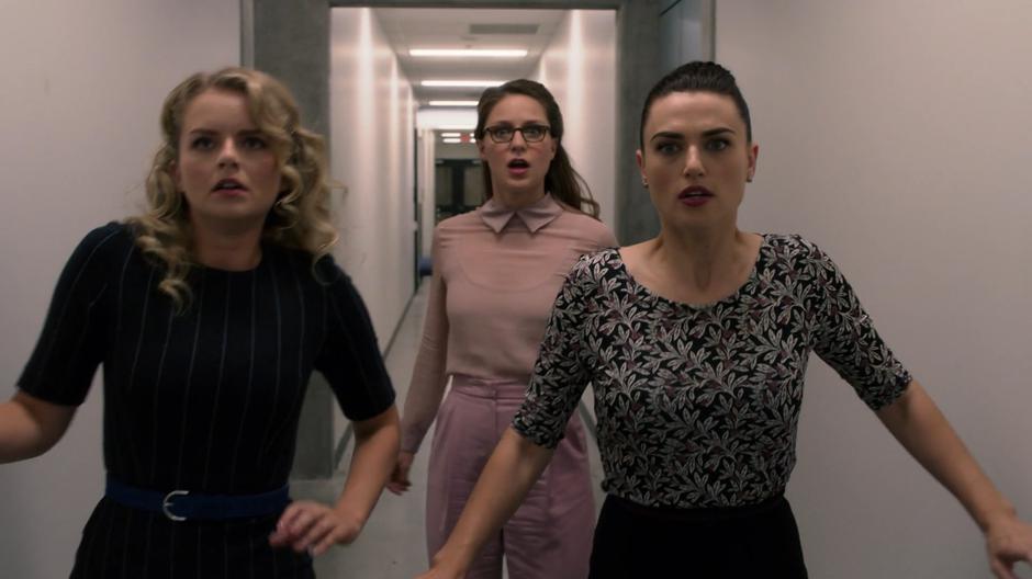 Eve, Kara, and Lena stop as a security door closes in front of them.