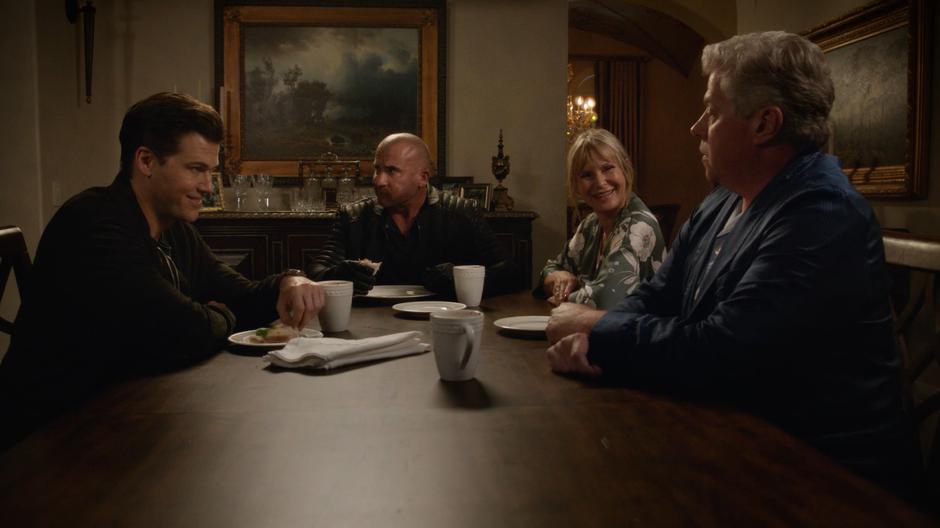 Nate, Mick, Dorothy, and Henry Heywood talk at the dining room table over sandwiches.