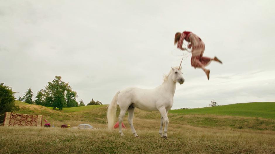 The hippie woman is thrown into the air after being gored by the unicorn's horn.