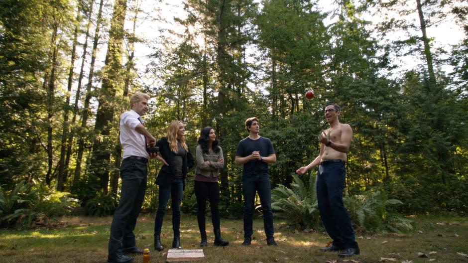 Constantine finishes preparing his spell while Sara, Zari, and Ray watch a shirtless Gary throw his pomegranate up into the air.