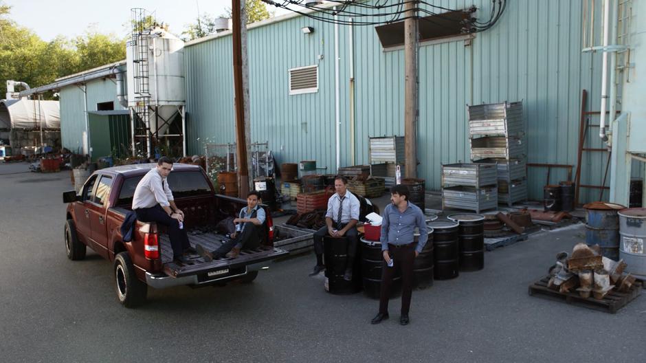 Ben Lockwood sits on the back of his pickup truck drinking and talking with several former foundry workers.