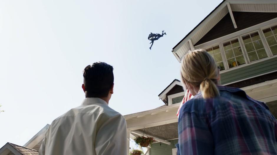 Ben and Lydia Lockwood look up as J'onn battles one of the Daxamites in the sky above their home.