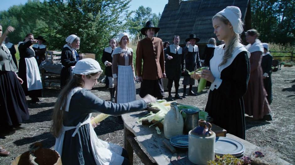 Prudence and Jane Hawthorne shuck corn as a man from the village accuses Jane of witchcraft.