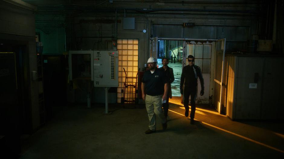 The plant foreman leads Sherloque and Ralph inside to show them the masks.