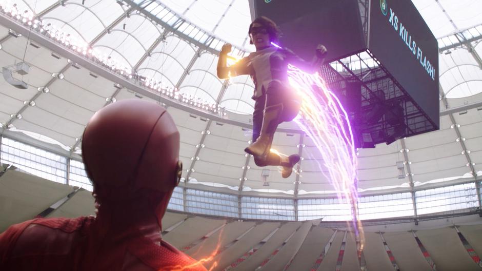 Nora leaps through the air to attack Barry as the "XS Kills Flash!" message displays on the screen behind her.
