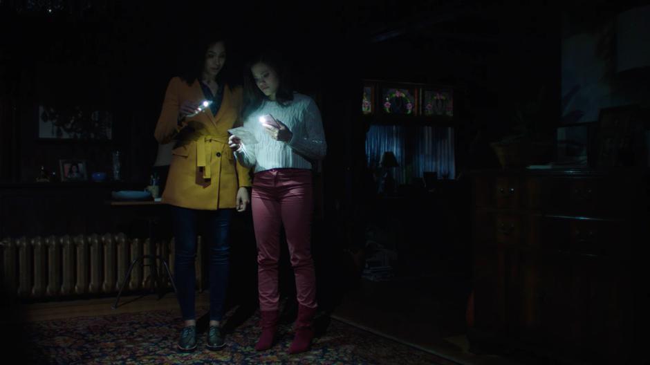 Macy and Maggie look at the picture of their mother in the house after the power goes out.