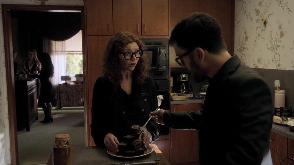 Stacey talks to Dale as he dishes out brownies onto her serving plate.