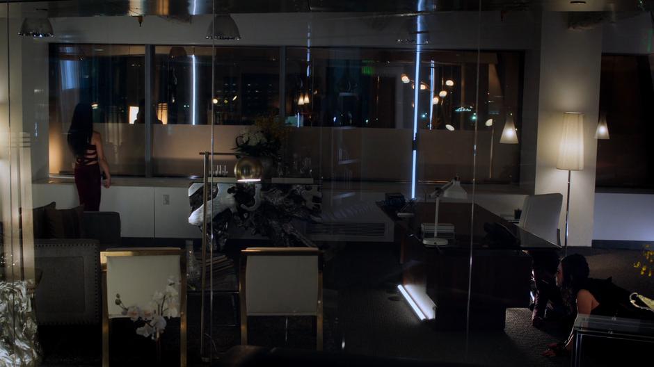 Tina walks into her office and looks out the window as Alex and Nico hide behind her desk.