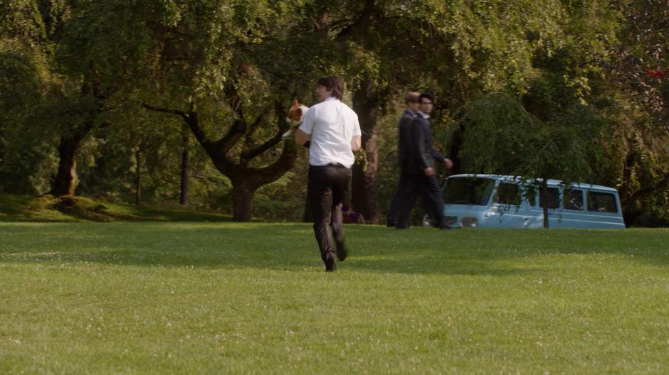 Ray runs back towards the van holding the stolen corgi.