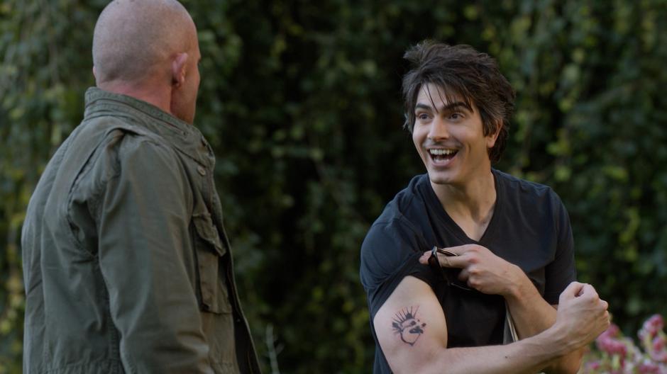 Ray excitedly shows Mick his new corgi tattoo.