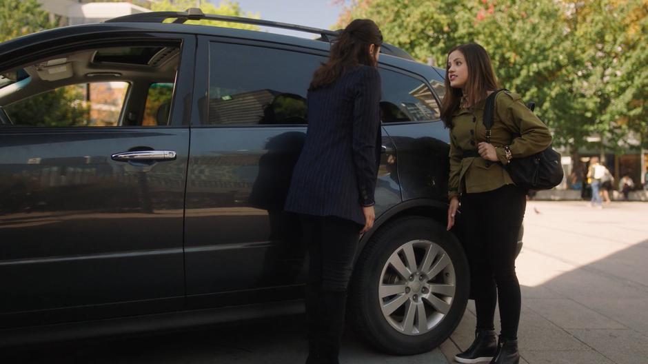 Maggie talks to Macy as they stand next to Mel's car.