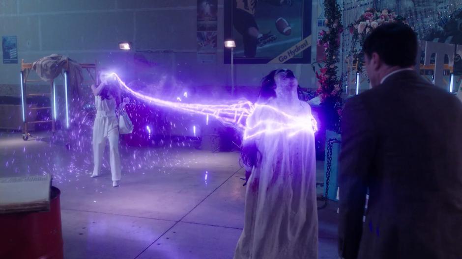Harry jumps back as Charity grabs hold of Angela Wu with a magical lightning whip.