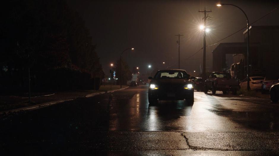 Tripp drives down the dark road near the warehouse.