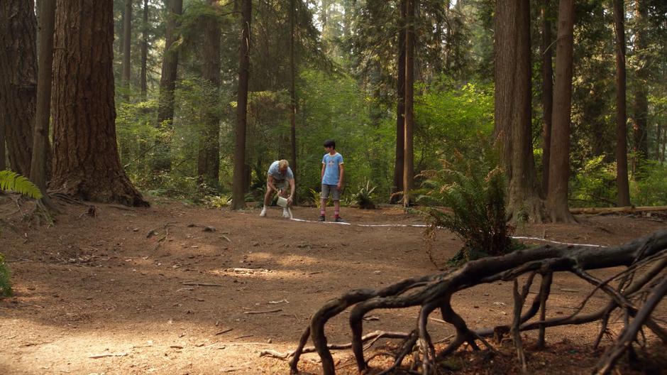 Constantine tells one of the campers what he is doing as he lays down a protective circle around the camp.