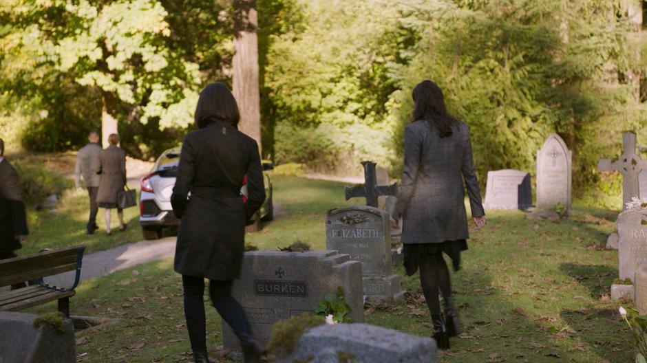 Niko and Mel walk between the graves back to their car.