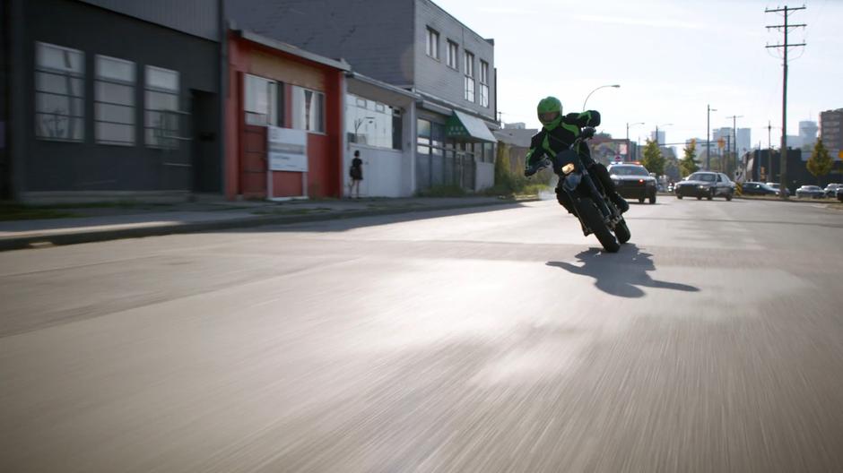 The motorcyclist weaves around traffic as the police chase after them.