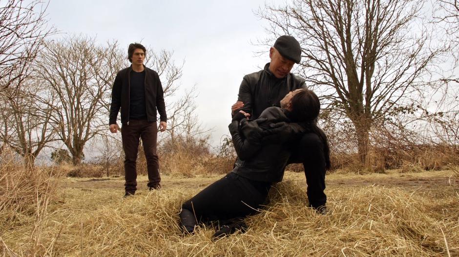 Ray watches as Damien holds a dying Nora in his arms.