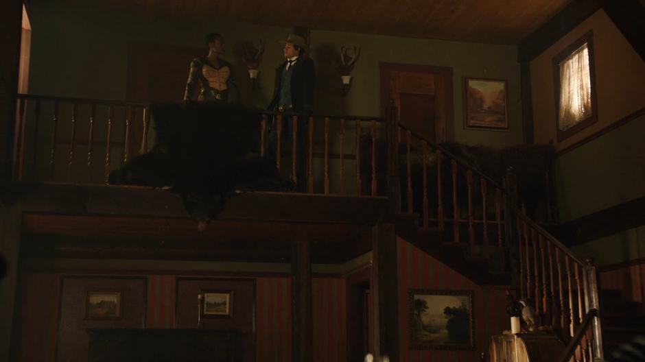Kuasa talks to Wally on the second floor of the saloon.