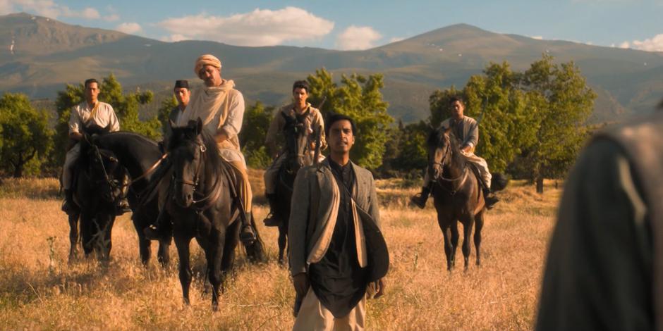 Manish talks to his brother in front of five men of horseback.