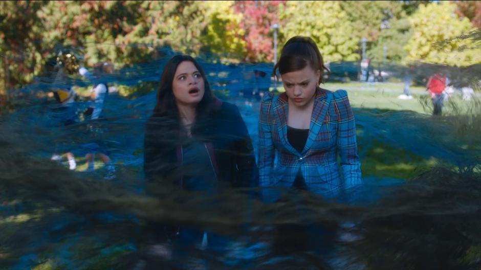 Mel and Maggie watch as the campus from 1989 appears around them in a swirl of magic.