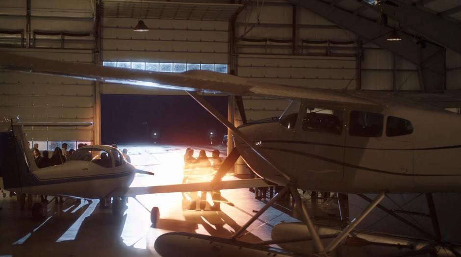 Barry zips a group of people to safety inside the hanger.