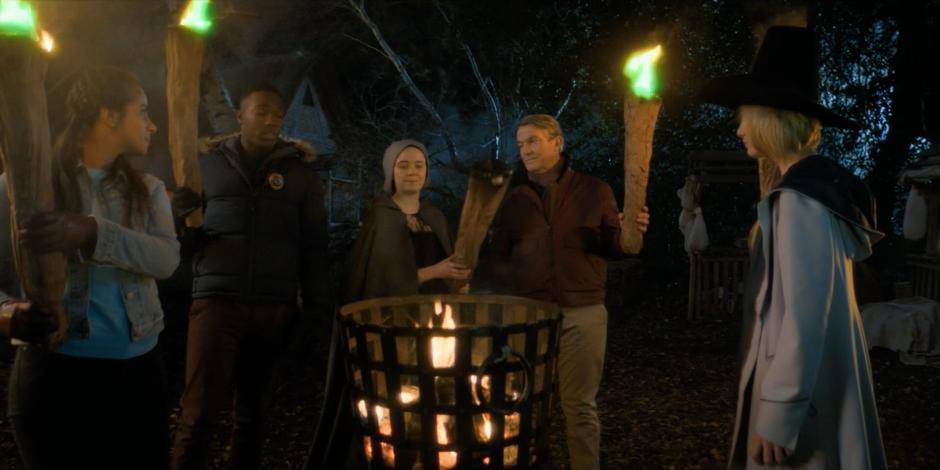 Willa joins Yasmin, Ryan, Graham, and the Doctor as they light their torches.