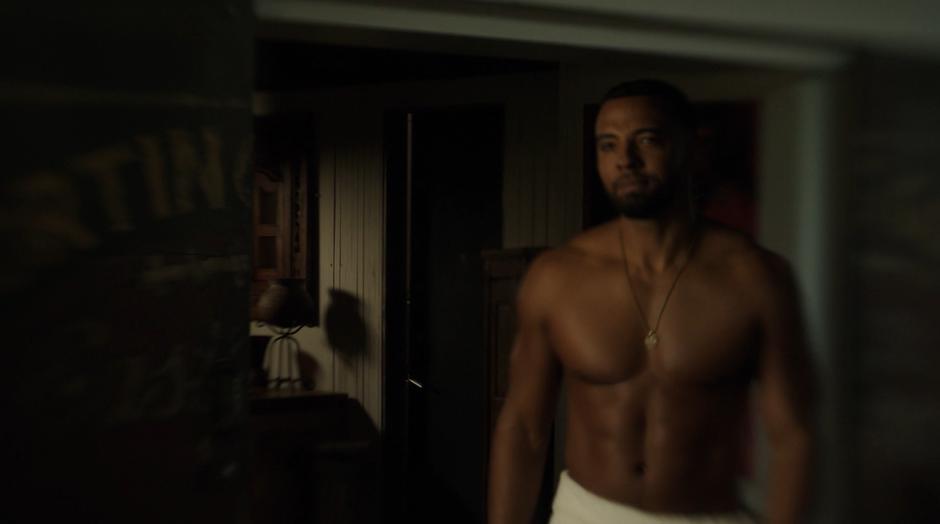 Desmond walks out of the bathroom wearing only a towel and his necklace.
